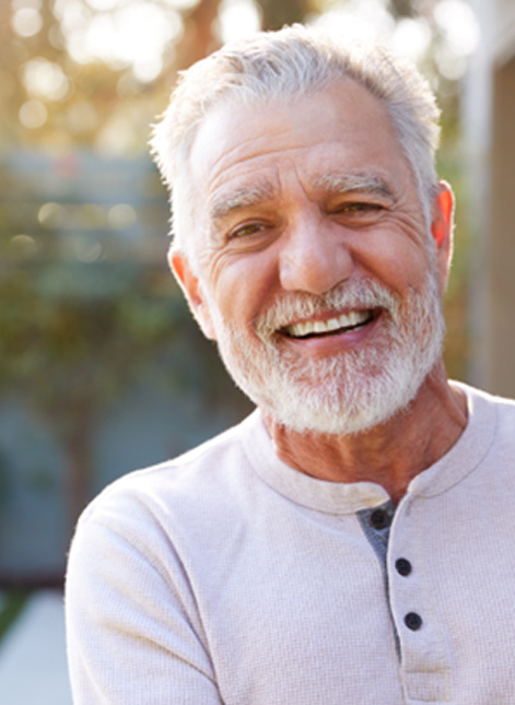 Senior man standing outside and smiling