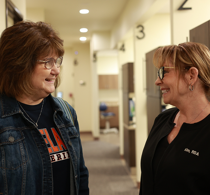 Dental assistant talking to patient