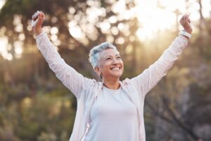 happy older woman with her hands raised with success